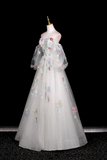 Elegant gown with floral embroidery on a mannequin against a black background