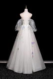 Elegant white dress with floral embroidery on a mannequin against a black background
