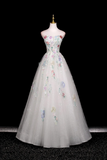 Elegant gown with floral embroidery on a mannequin against a black background