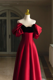 Red evening gown with black bodice on a mannequin against a neutral background