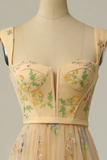 Mannequin wearing a beige dress with floral embroidery on a plain background