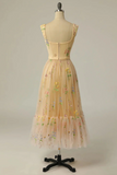 Vintage-style dress with floral embroidery on a mannequin against a plain background