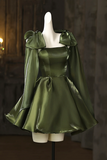 Green satin dress with large bow sleeves on a mannequin against a dark background