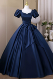 Navy blue gown on a mannequin against a neutral background