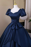 Navy blue evening gown on a mannequin against a neutral background