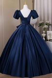 Navy blue evening gown on a mannequin against a neutral background