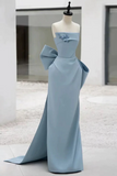 Light blue evening gown with a large bow on a mannequin against a white background