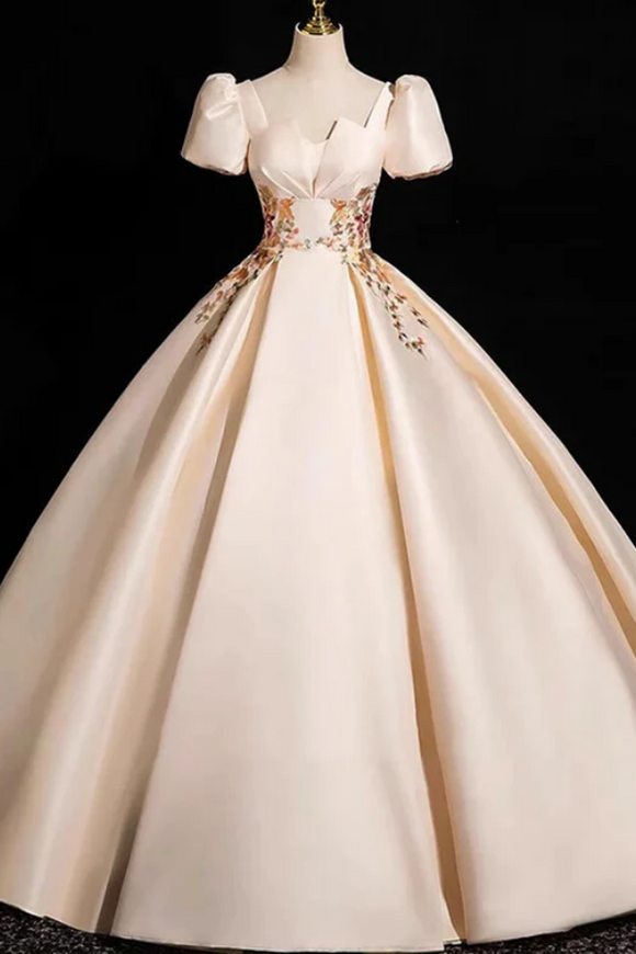 Beige evening gown with floral details on a black background