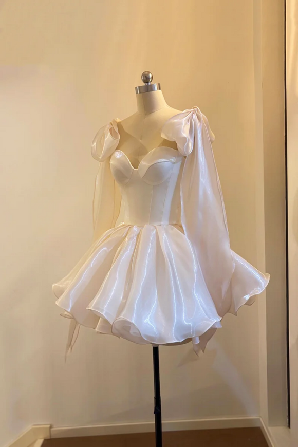 White dress on a mannequin against a plain wall