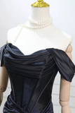 Navy blue satin dress on a mannequin with pearl necklace against a white background