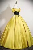 Yellow evening gown on a mannequin against a plain background