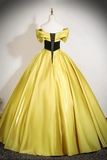 Yellow evening gown on a mannequin against a plain background
