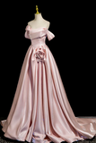 Pink evening gown on a mannequin against a black background
