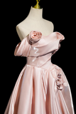 Pink evening gown with floral details on a mannequin against a black background