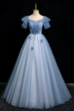 Light blue evening gown on a mannequin against a black background