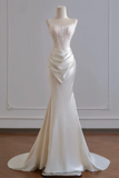 White evening gown on a mannequin against a plain background
