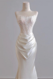 White wedding dress on a mannequin against a plain background