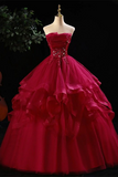 Red ball gown on a mannequin against a dark background