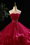 Red strapless gown with sequin details on a mannequin against a dark background