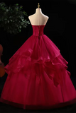 Red ball gown on a mannequin against a dark background