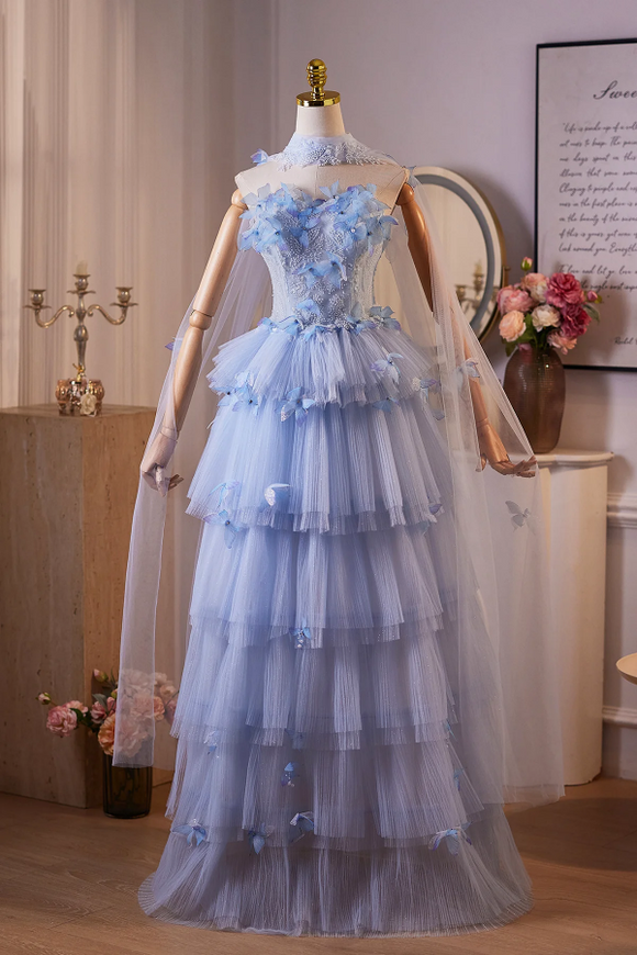 Blue tiered dress on a mannequin in a room with flowers and decor.
