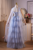 Mannequin wearing a light blue dress with a sheer overlay in a room setting.