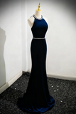 Navy blue evening gown on a mannequin against a white wall.