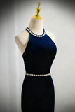 Navy blue dress with white pearl details on a mannequin against a gray background