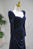 Navy blue evening gown on a mannequin against a plain background