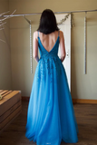 Woman wearing a blue evening gown with a low back, standing in a room.
