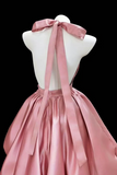 Pink satin dress on a mannequin against a black background