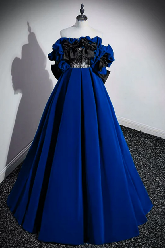 Blue evening gown with black floral details on a mannequin against a white wall.