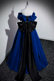 Blue and black evening gown on a mannequin against a plain background