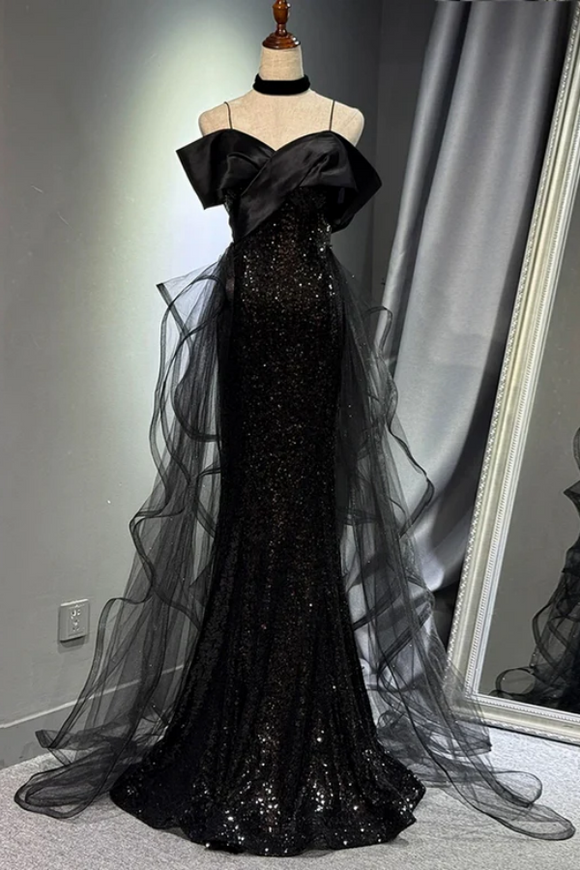 Black evening gown with sheer overlay on a mannequin against a neutral background