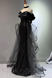 Black evening gown with sheer overlay on a mannequin against a neutral background