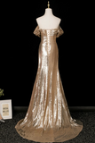 Gold sequin evening gown on a mannequin against a black background