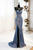 Blue evening gown on a mannequin against a white curtain background