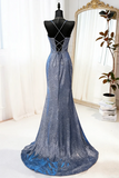 Blue evening gown on a mannequin in front of a mirror with a plant in the background