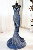 Blue evening gown on a mannequin against a white curtain background