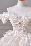 Close-up of a white lace wedding dress on a mannequin against a neutral background