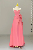 Pink evening gown on a mannequin against a plain background