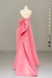 Pink evening gown with a large bow on a mannequin against a neutral background