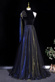 Mannequin wearing a black top and blue tulle skirt with a gold accent against a dark background.