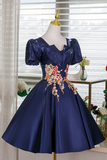 Navy blue dress with floral embroidery on a mannequin against a neutral background