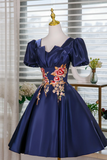 Navy blue dress with floral embroidery on a mannequin against a window background.