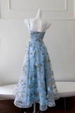 Blue floral dress on a mannequin against a white wall