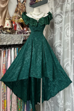 Green lace dress on a mannequin against a patterned curtain background