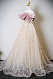 Lace wedding dress with a large pink bow on a mannequin against a plain background