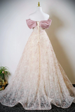 Lace wedding dress with a large pink bow on a mannequin against a neutral background