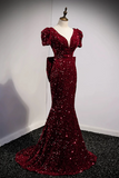 Burgundy sequin evening gown on a mannequin against a plain background